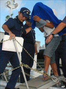 Chinese boat captain Zhan Qixiong, right, is led by Japanese coast guard officials