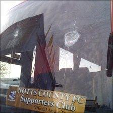 Smashed window of supporters' coach