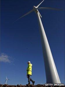 A worker walks past wind turbines