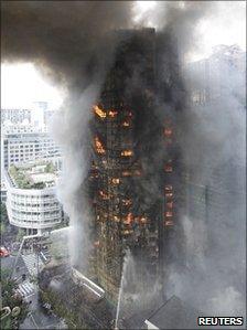 Firefighters try to extinguish a fire at a building in Shanghai, China, 15 November 2010