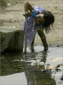 A little girl drinks water from a tap at a refugee camp 20 kilometres south of the Shiite holy city of Najaf, 160 kilometres (100 miles) south of Baghdad, Iraq