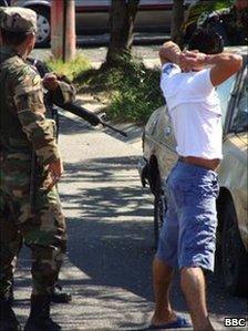 Police officer detains suspected gang member in San Salvador (December 2010)