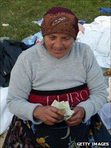 Romanian lady counts her lei