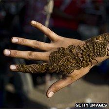 Application of henna or 'Mahendi' to a girl's hand in a market in Jaipur, India, October 2010.