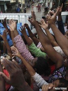 Residents reach for relief supplies following a landslide in their area of Nova Friburgo on Sunday