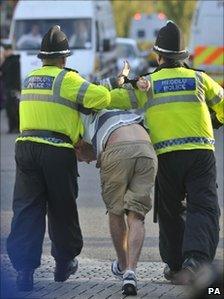 A man is arrested by police and led away