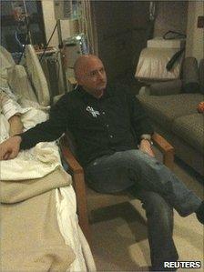 Mark Kelly watches Mr Obama's State of the Union address at Ms Giffords' bedside