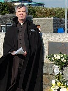 Reverend Andrew Sharp by Guernsey's Holocaust memorial plaque