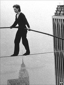 Philippe Petit tightropes between the Twin Towers in 1974