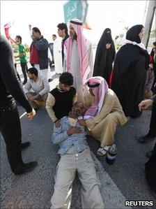 A protester, who collapsed after inhaling tear gas, lies on the ground, 14 February 2011
