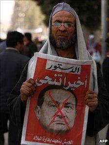 A member of the Muslim Brotherhood organisation hold the cover of a local paper depicting former Egyptian President Hosni Mubarak, 2011