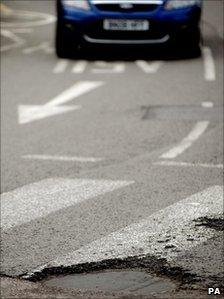 Car approaching pothole