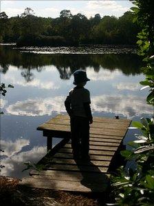 Silhouette of a child standing on a jetty