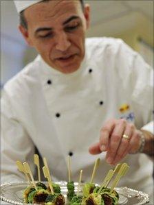 Royal chef Mark Flanagan, head of kitchens at Buckingham Palace, arranges a tray of bubble and squeak confit with shoulder of lamb canapés