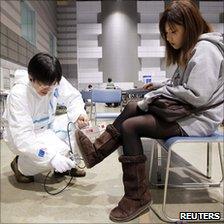 A Japanese woman is checked for radiation