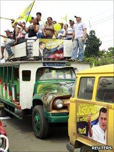 Ecuadorean demonstrators in favour of an upcoming referendum stand on the top of a bus during a political rally in Tosagua May 3, 2011