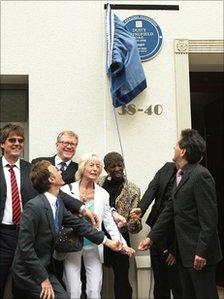 The blue plaque being unveiled