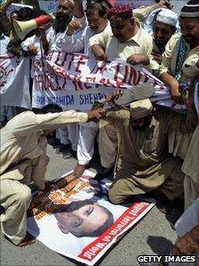 Pakistani protesters beating a poster of US President Barack Obama