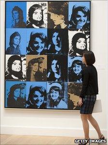 A woman views Andy Warhol's Sixteen Jackies