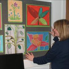 Intern hanging paintings in museum