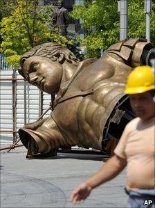 A construction worker passes the trunk of the Alexander statue in Macedonia's capital Skopje, 14 June