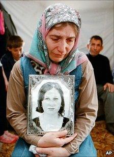 Roza Bashayeva, 40, holds a portrait of her dead teenage daughter Elza Kungayeva (image from 2001)