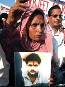 Sarabjit Singh's wife Sukhpreet Kaur holds a photograph of her husband