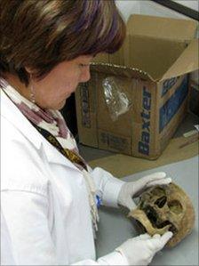 Forensic worker examines a skull at Colombia's national institute of forensic medicine