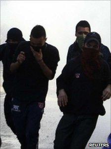 Demonstrators run away from a jet of water released from a riot police vehicle during a students' rally to demand changes in the public state education system in Santiago, 9 August 2011