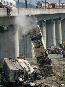 Workers clear wreckage of mangled carriages after a Chinese high-speed train derailed, July 24, 2011