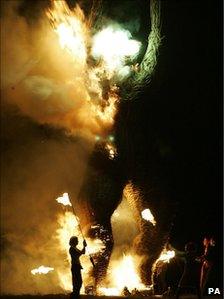 Fire dancers torch a giant Wicker Man at the Wickerman Festival, Kirkcudbright