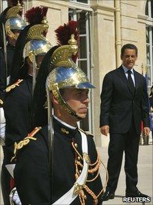 French President Nicolas Sarkozy stands beside guards outside the Elysee Palace in Paris, 16 August