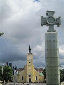 An independence monument stands in front of a church in Tallinn