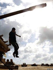 A rebel fighter jumps from a T-55 tank in Misrata on 29 August 2011