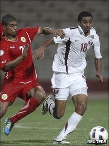 Qatar's Mohammed el-Sayed (white kit) fights for the ball with Bahrain's Mohammed Hussain