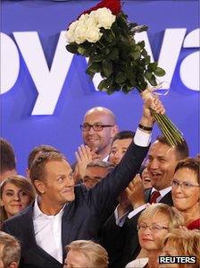 Poland's Prime Minister Donald Tusk waves to supporters after the election results announcement in Warsaw, 9 October 2011