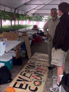 Two men talk at a table at Occupy Nashville