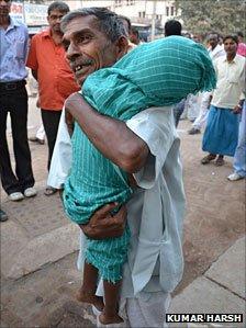 A man holding the body of a child who died of encephalitis at a Gorakhpur hospital