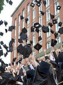 Graduates throwing mortar boards