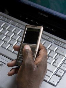 Woman using mobile phone and laptop