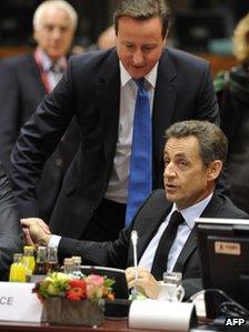 UK Prime Minister David Cameron stands behind French President Nicolas Sarkozy at the Brussels summit, 26 October