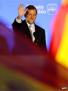 Leader of the Spanish Popular Party (PP) Mariano Rajoy (C) waves to supporters from the balcony of the PP headquarters in Madrid on 20 November 2011