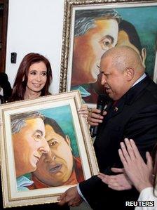 Hugo Chavez (right) presents Argentina's Cristina Fernandez with a painting he did of himself and her late husband Nestor Kirchner