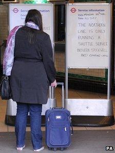 A woman reads a sign at Clapham North Tube station on Monday