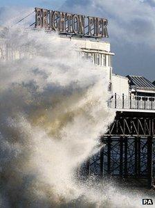 Waves crash on the seafront near Brighton Pier in Brighton, East Sussex