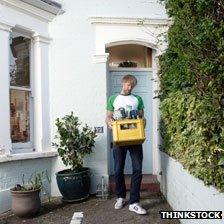 Man carrying recycling box full of empty wine and beer bottles