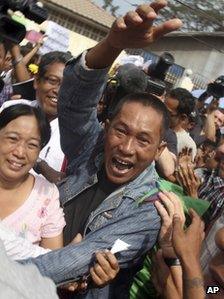 A Myanmar political prisoner waves in jubilation as he is released from Insein prison in Rangoon, Burma, on Friday