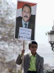 A boy carries a poster with a picture of outgoing Yemeni President Ali Abdullah Saleh while attending weekly Friday prayers, during a rally to show support for Saleh, in Sanaa January 20, 2012