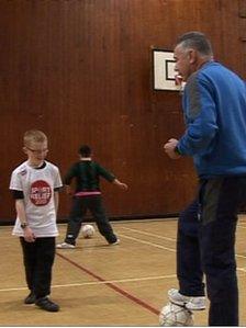 Paul Reynolds playing football with the children