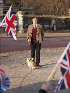 Stephen Fry at Buckingham Palace with a corgi. Photo: VisitEngland